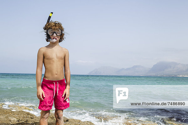 Spain  Boy with diving equipment on beach