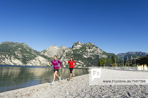 Italy  Mid adult couple jogging by Lake Garda