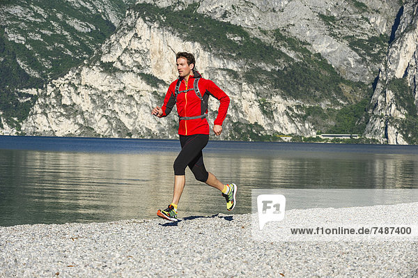 Italy  Mid adult man jogging by Lake Garda