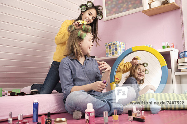 Mädchen mit Haarroller beim Schminken