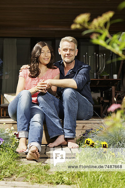 Deutschland  Berlin  Reife Paare entspannen sich auf der Terrasse  lächelnd  Portrait