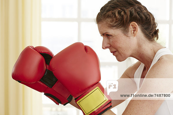 Reife Frau mit Boxhandschuh  Nahaufnahme