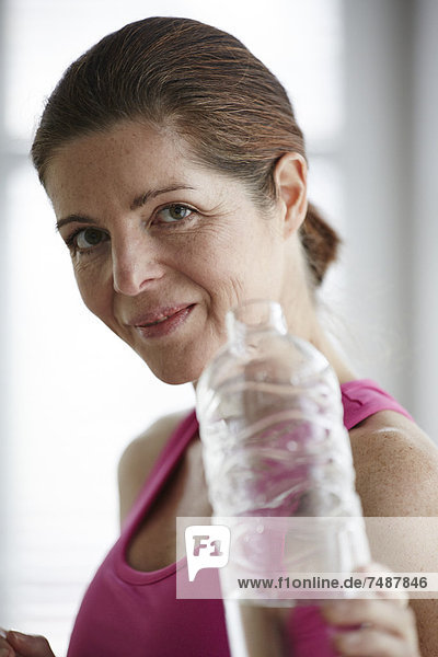 Reife Frau trinkt Wasser nach dem Sport