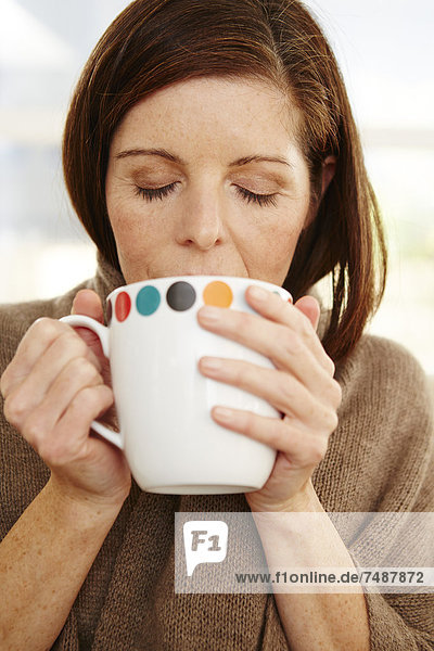 Mature woman drinking coffee  close up