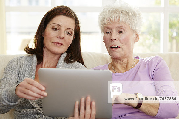 Frauen mit digitalem Tablett und Entspannung zu Hause