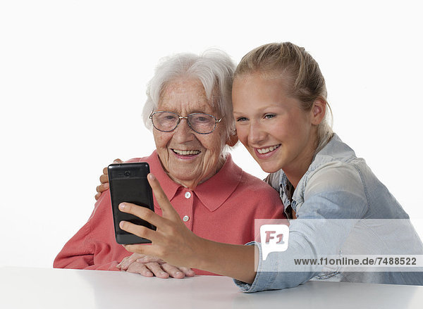 Senior woman and teenage girl taking photo of themselves  smiling