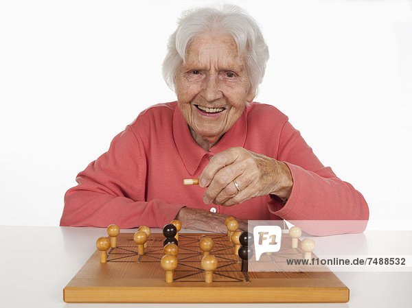 Portrait of senior woman playing Fox And Hen Game  smiling