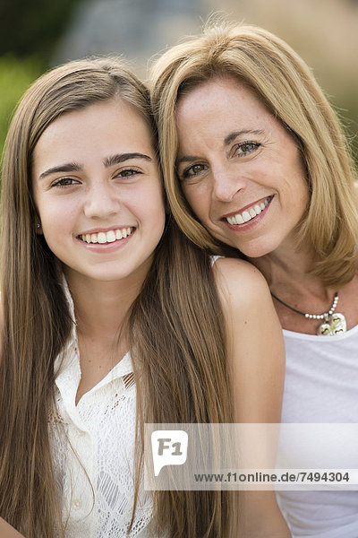 Caucasian mother and daughter smiling outdoors