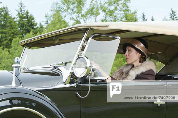 Caucasian woman driving vintage car