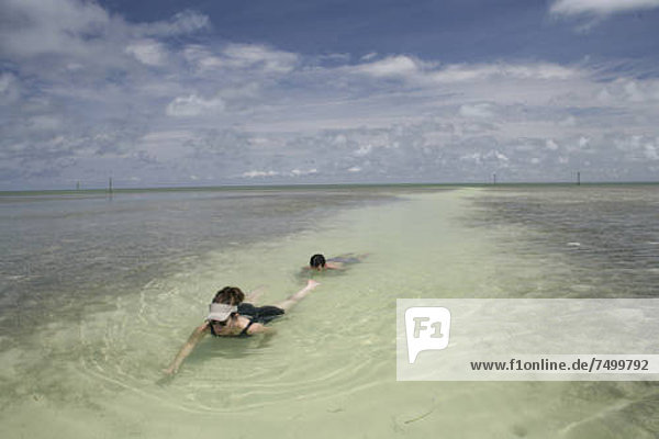 Woman and man swimming in water