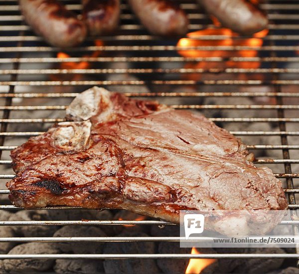Steak and sausages on a barbeque