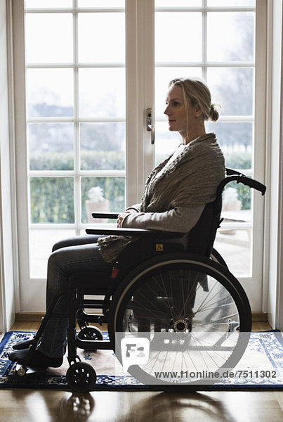 Side view of disabled woman in wheelchair at home