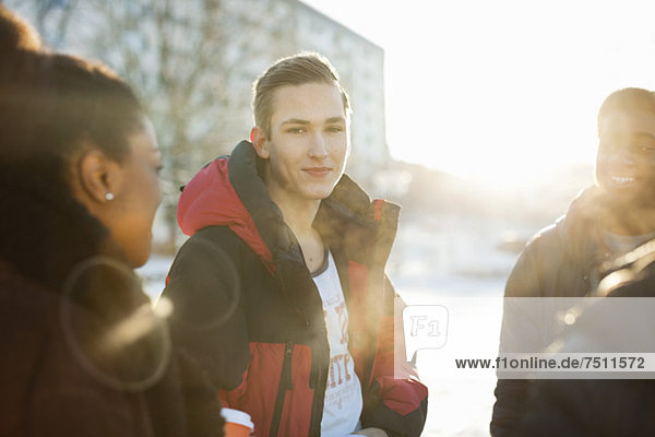 Porträt eines jungen Mannes mit Freunden im Winter