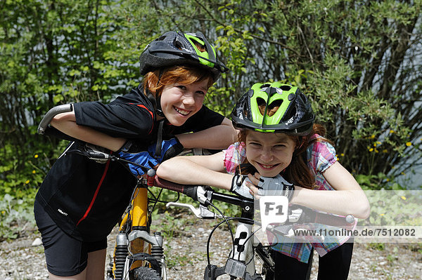 Two children  boy and girl with mountain bikes and helmets