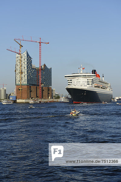 Cruise liner RMS Queen Mary 2 leaving the harbour  Elbe Philharmonic Hall under construction