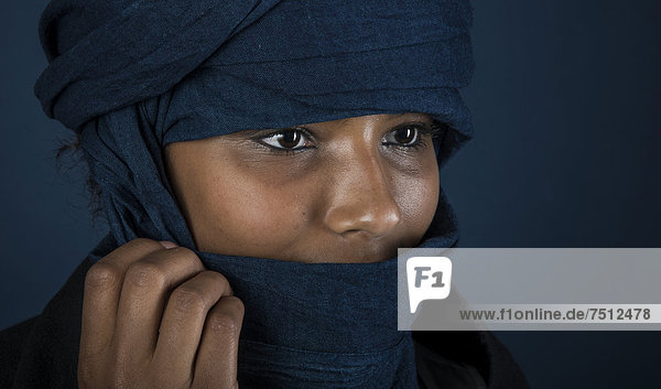 Tuaregmädchen  Targia  verschleiert mit Chech  Gesicht geheimnisvoll verhüllt mit Hand  Portrait  Algerien  Nordafrika
