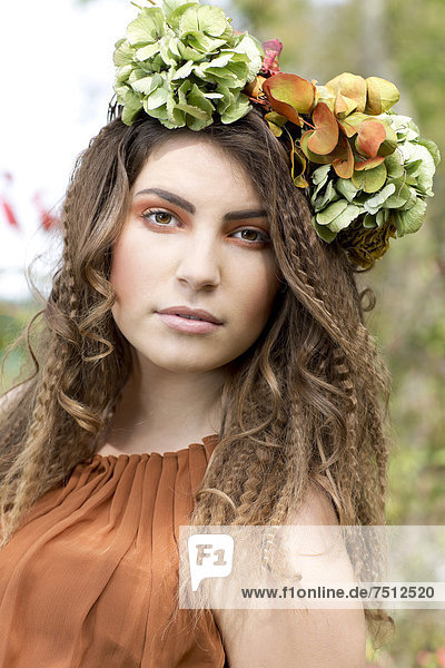 Young woman with a flowal wreath in her hair  outdoors  portrait