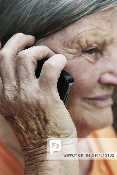 Seniorin telefoniert mit einem Smartphone