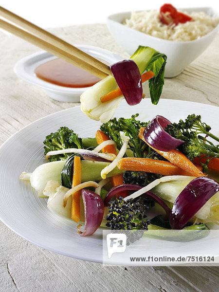 Orientalisches Wok-Gemüse  mit Ess-Stäbchen  mit Reis und einem Chili-Dip