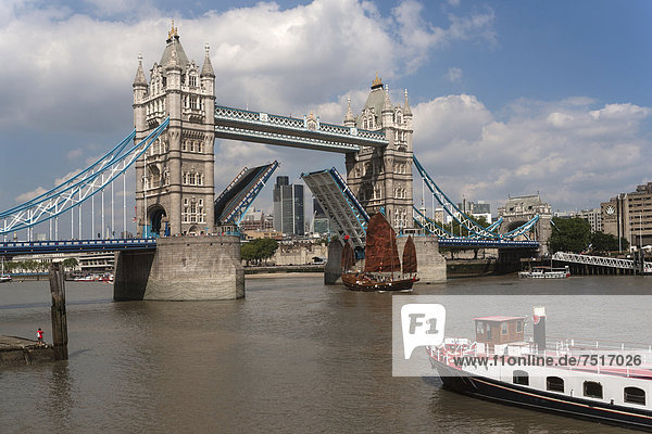 Eine Dschunke passiert die offene Tower Bridge  Schiffspassage  geöffnete Baskülen  Themse  London  England  Großbritannien  Europa