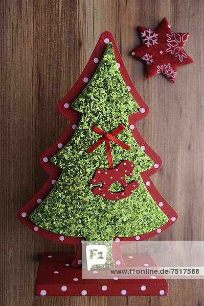 Miniaturweihnachtsbaum und Stern auf Holzuntergrund