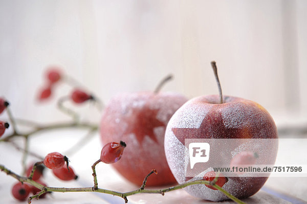Weihnachtsambiente mit roten Äpfeln und Hagebutten