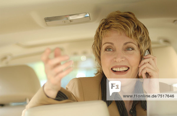 Businesswoman making a phone call in a car