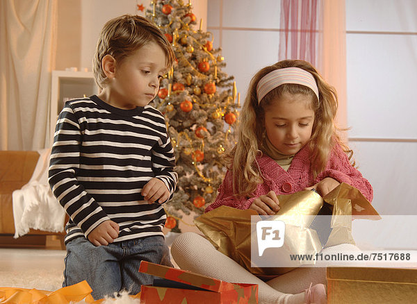 Geschenk Junge - Person verpacken frontal Weihnachtsbaum Tannenbaum Mädchen