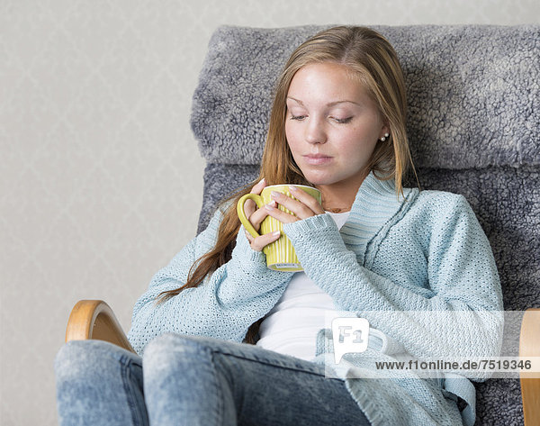 Young woman at home  relaxing  holding a mug