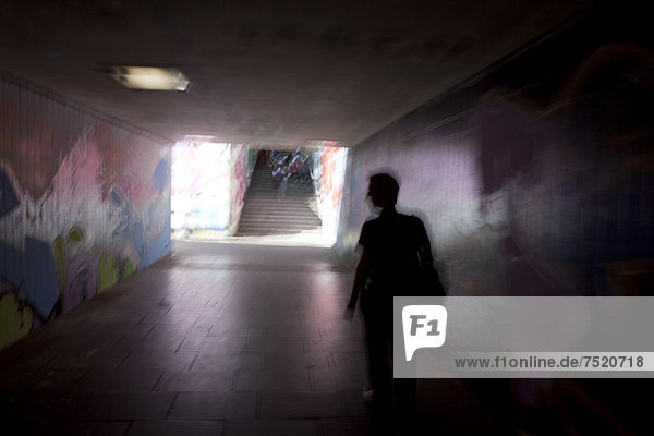 A man walking in a dark tunnel with graffiti  symbolic image for anxiety  panic  Trier  Rhineland-Palatinate  Germany  Europe