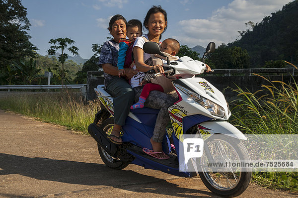 Women and children on a motorbike  northern Thailand  Thailand  Asia