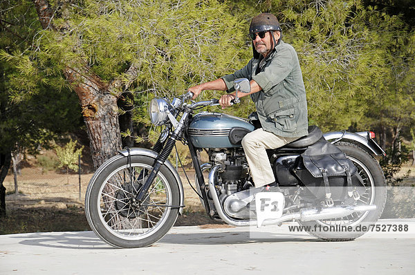 Älterer Mann fährt auf einer Triumph Tiger 500 cc  Baujahr 1956  englisches Motorrad  Altea  Costa Blanca  Spanien  Europa  ÖffentlicherGrund
