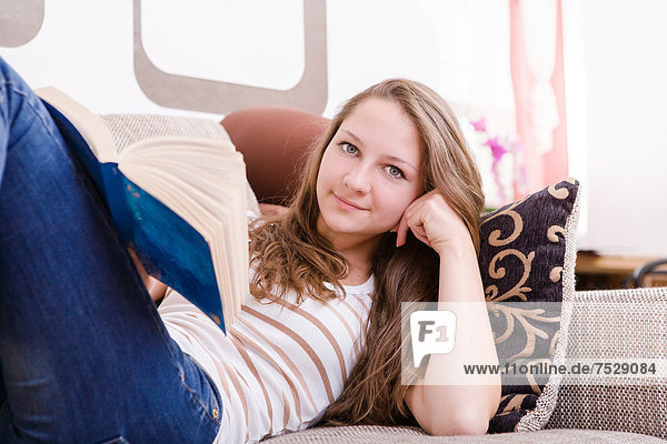 Girl reading a book on the sofa
