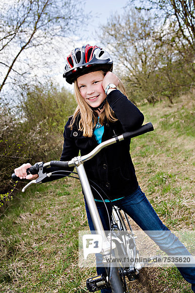 Girl with a cycling helmet and a bike