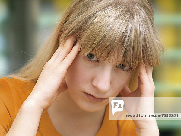 Junge Frau reibt sich die Schläfen  Kopfweh  Migräne