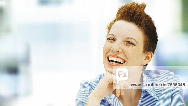 Geschäftsfrau mit Punkfrisur  im Büro  lachend  entspannt