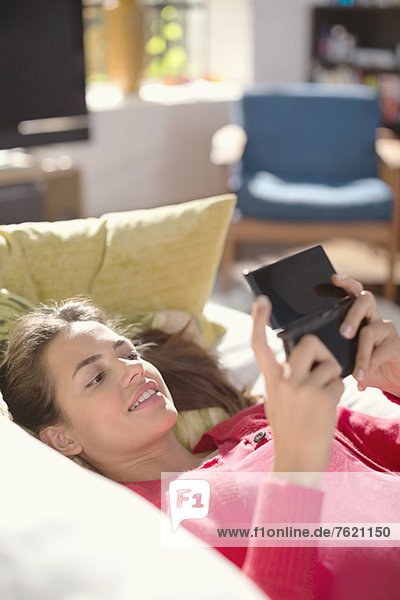 Woman playing video games on sofa