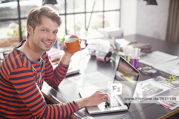 Man using laptop with cup of coffee