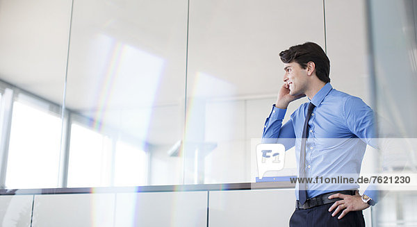 Businessman talking on cell phone in office
