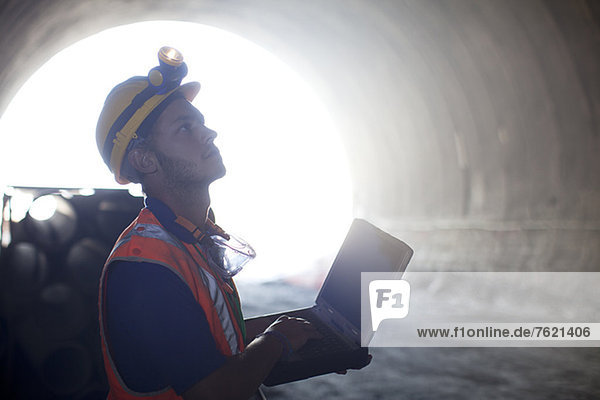 Arbeiter mit Laptop im Tunnel