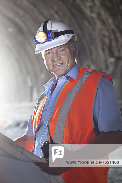 Geschäftsmann liest Blaupausen im Tunnel