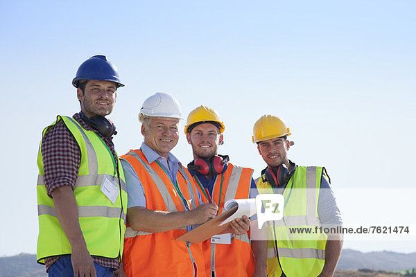 Businessman and workers smiling on site