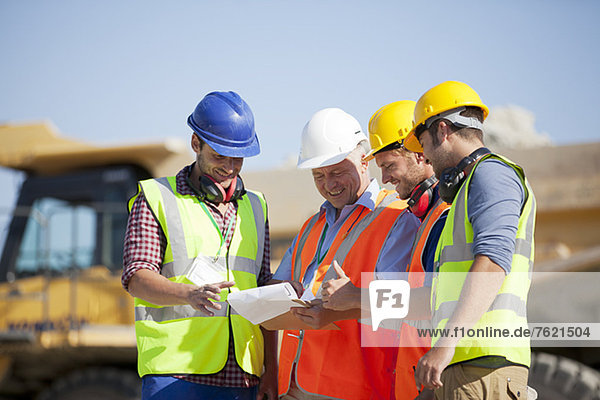 Workers and businessman talking in quarry