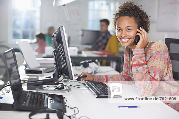 Businesswoman talking on phone at desk