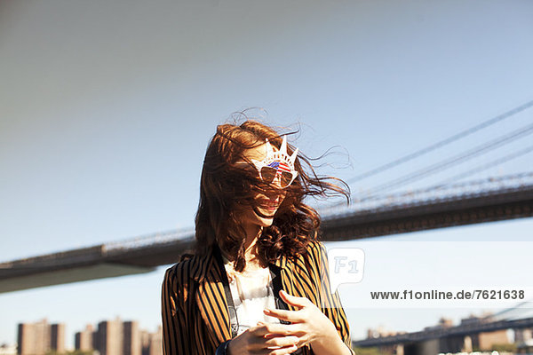 Woman in novelty sunglasses by city cityscape