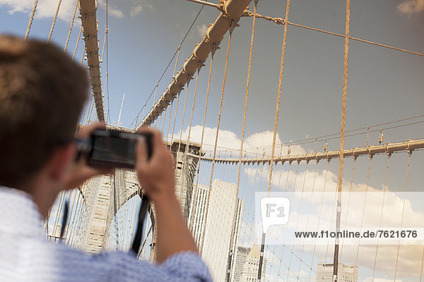 Man taking picture of urban bridge