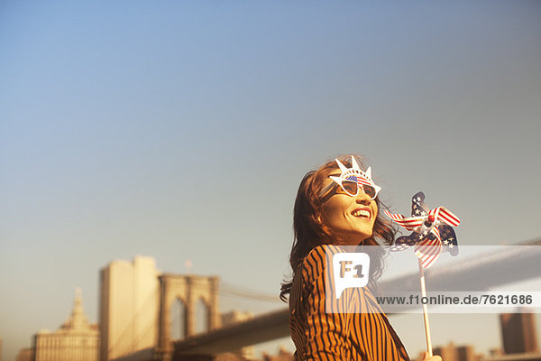 Woman novelty sunglasses with pinwheel by urban bridge