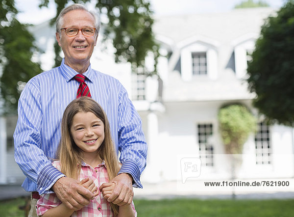 Mann und Enkelin lächeln im Freien
