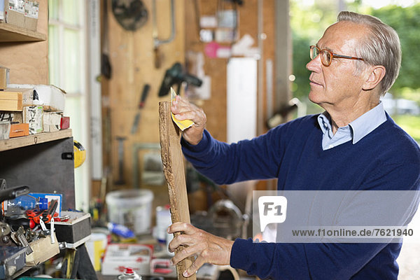 Man sanding wood in garage