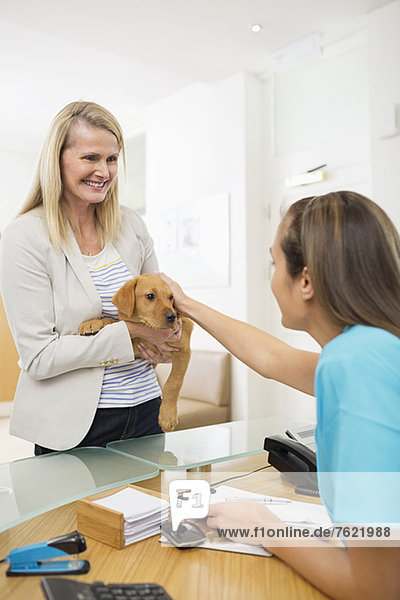 Besitzer bringt Hund zur Tierarztpraxis